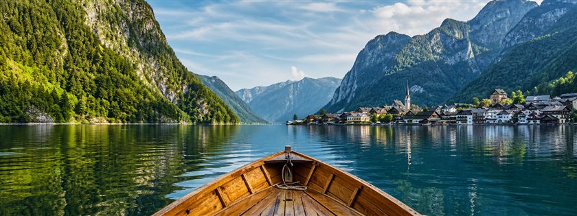 A wooden boat crossing a scenic mountain lake